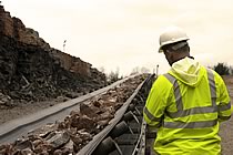 Man in hard hat next to conveyor.