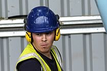 Worker in a blue helmet, concentrating hard.