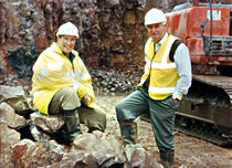 Management standing proudly in front of their machinery.