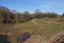 Pond and recently turfed bank in spent quarry.