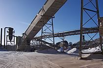 Conveyors semi-silhouetted against a blue sky.